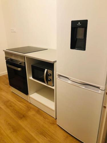 une cuisine avec un réfrigérateur et un micro-ondes dans l'établissement Magnifique Maison avec parking sur place, à Filay