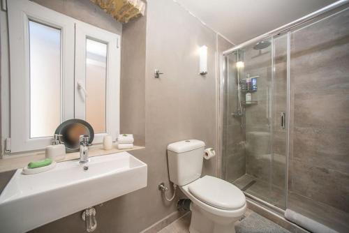 een badkamer met een toilet, een wastafel en een douche bij Newly Renovated 1730's Venetian Loft (01) ! in Corfu-stad