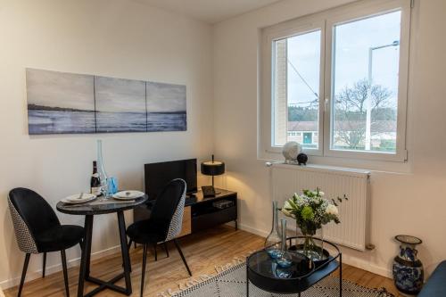 a living room with a table and chairs and a window at DIFY Industriel - Parilly in Vénissieux