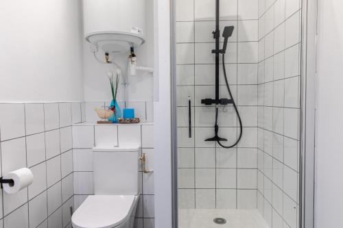 a white bathroom with a shower and a toilet at DIFY Industriel - Parilly in Vénissieux