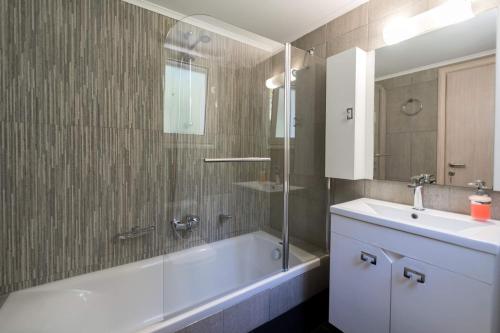 a bathroom with a tub and a sink and a shower at Diwani Luxury Villas in Lixouri