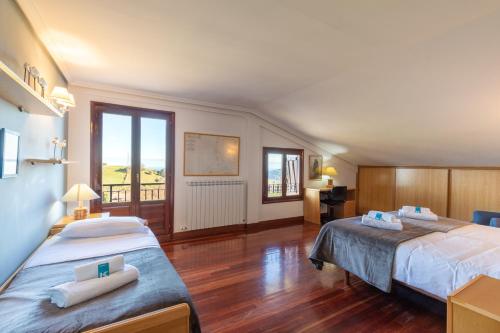 Habitación de hotel con 2 camas y balcón en Casa Rural Zelaieta BerriBi, en Itziar