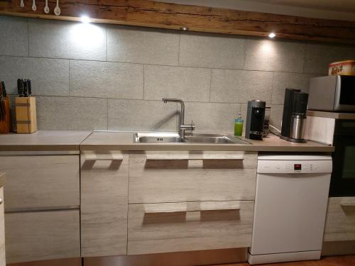 una cucina con lavello e microonde di APPARTAMENTO CORTINA 1956 a Cortina dʼAmpezzo