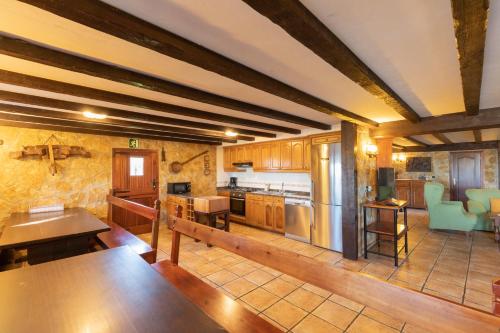 una gran cocina con armarios y mesas de madera. en Casa Rural Zelaieta BerriBi, en Itziar