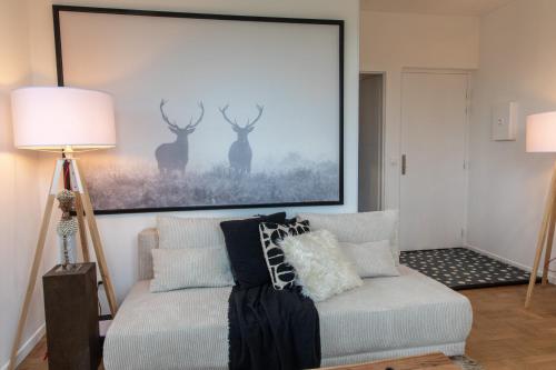 una sala de estar con sofá y una foto de ciervo en DIFY Chalet a la ville - Parilly, en Vénissieux