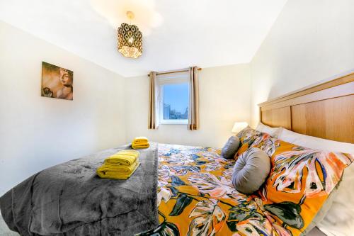 a bedroom with a large bed with a colorful comforter at Kings Lodge - Grampian Lettings Ltd in Aberdeen