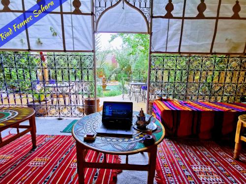 a room with a laptop on a table in a tent at Riad Fennec Sahara in Zagora