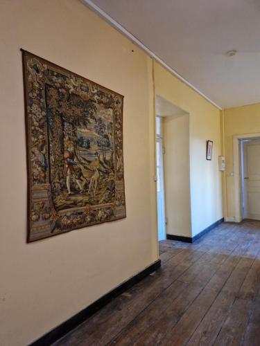 a large tapestry hanging on a wall in a hallway at Château St Justin in Saint-Justin