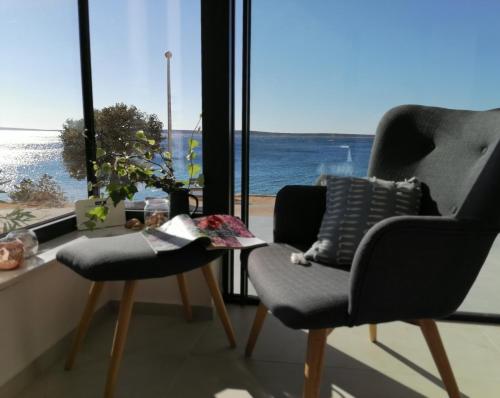 two chairs and a table in a room with a view of the ocean at Bella Mare in Mandre