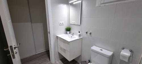 Baño blanco con lavabo y aseo en Apartamento Happy Place Madrid en Madrid