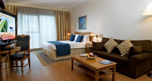 a hotel room with a bed and a couch at Millennium Plaza Downtown, Dubai in Dubai