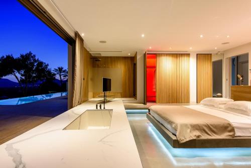 a bedroom with a large bed and a tv at Sa Caleta Hill in Sant Josep