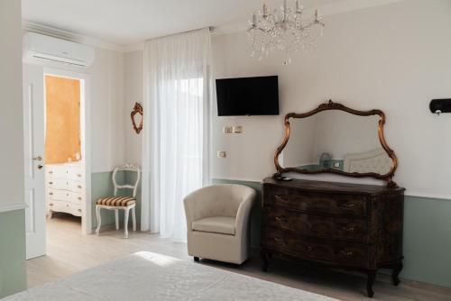 a bedroom with a dresser and a chair and a mirror at B&B Domus Aurea 20 in San Giovanni Teatino