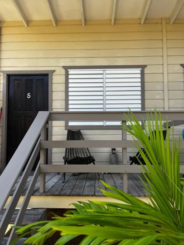 a bench on the front porch of a house at DreamCabanas in Caye Caulker