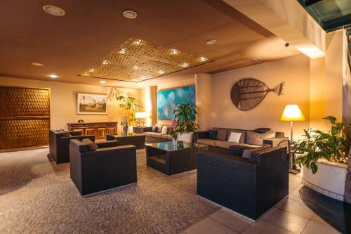 a lobby with couches and tables and plants at Hotel Mercedes in Ilhabela