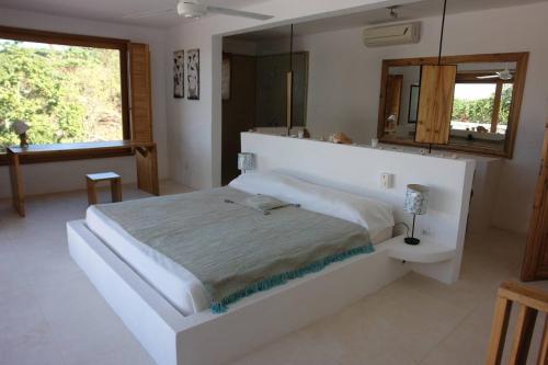 a bedroom with a large white bed and a mirror at Propiedad de alto standing con vista al mar, piscina, tenis, hasta 12 personas in Las Terrenas