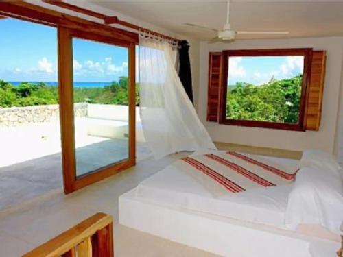 a bedroom with a bed with a view of the ocean at Propiedad de alto standing con vista al mar, piscina, tenis, hasta 12 personas in Las Terrenas