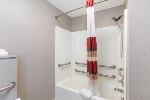 a bathroom with a shower and a tub at Red Roof Inn & Suites Corbin in Corbin