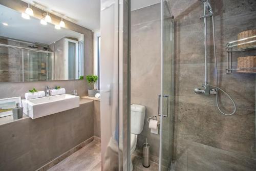 a bathroom with a shower and a toilet and a sink at Newly Renovated 1730's Venetian Loft (02) ! in Corfu