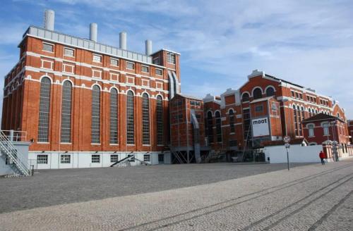a large red brick building with a person standing in front of it at Timeless Charming - Belém in Lisbon