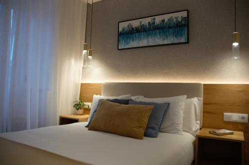 een slaapkamer met een wit bed met een foto aan de muur bij Timeless Charming - Belém in Lissabon