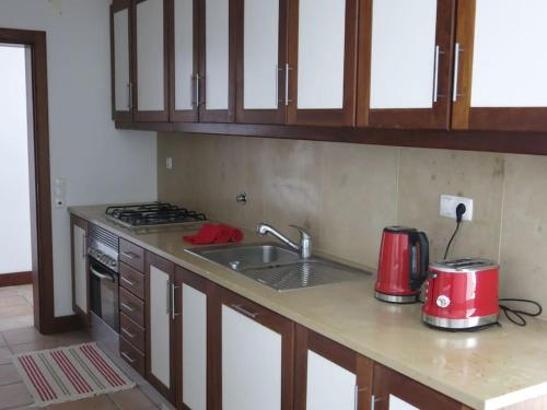 a kitchen with a sink and a stove top oven at Sea wave sounds, Meco, by the beach in Sesimbra