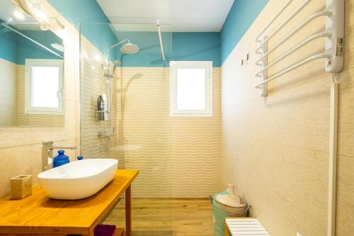 a bathroom with a large white sink on a wooden table at Casa Flor in Zahora