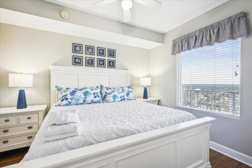 a white bedroom with a bed and a window at Gone Coastal - Tidewater Beach Resort #2410 by Book That Condo in Panama City Beach