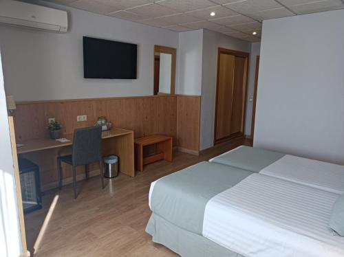 a bedroom with a bed and a desk and a television at Mendez Nuñez Alicante in Alicante
