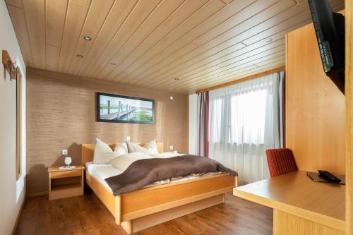 a bedroom with a bed and a desk and a window at Haus Gafrina in Schruns