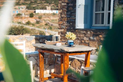 una mesa de madera con un jarrón de flores en el patio en Oniropagida, en Apollonia