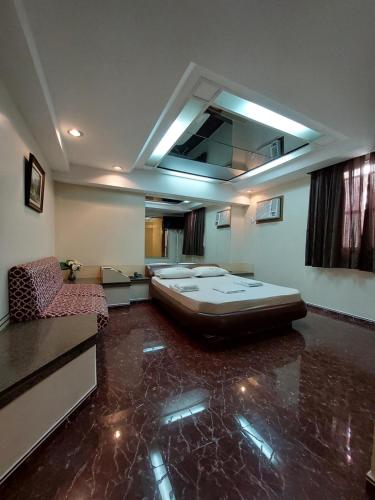 a room with a bed in the middle of a room at Hotel Fênix (Adult Only) in Rio de Janeiro