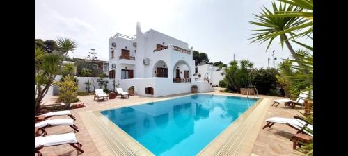 a villa with a swimming pool in front of a house at Villa Almyra in Aegina Town