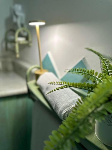 a bathroom counter with a towel and a plant at La Scala di Atena in Agrigento