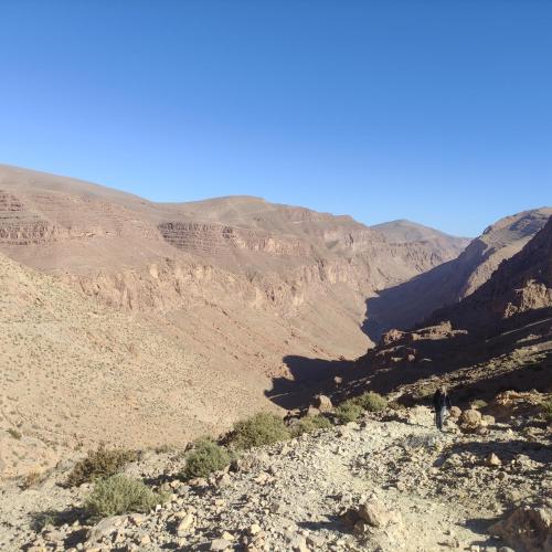 a person standing on a mountain looking down at a valley at Riad Al Anwar in Tinerhir