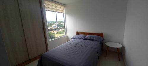 Habitación pequeña con cama y ventana en Apartamento Armenia Quindio, en Armenia