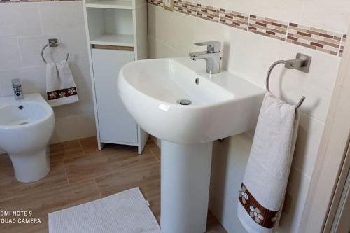 a bathroom with a white sink and a toilet at Casa Bellavista in Villarios