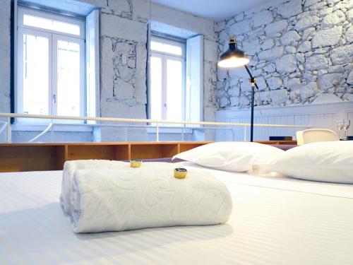 a hotel room with two beds with a towel on the bed at Apartamentos Premium Familiares - Loft Guesthouse BeMyGuest Viseu in Viseu