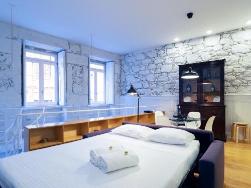 ヴィゼウにあるApartamentos Premium Familiares - Loft Guesthouse BeMyGuest Viseuのベッドルーム(大型ベッド1台、テーブル付)