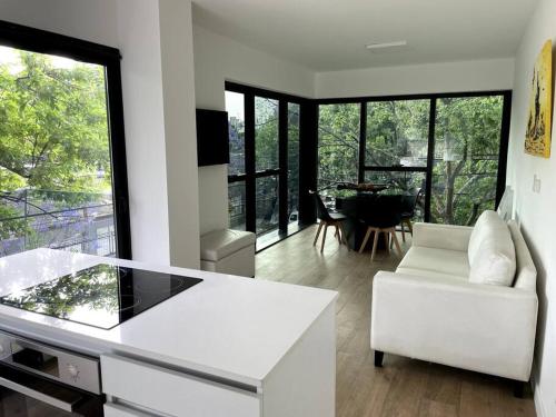 sala de estar con muebles blancos y ventana grande en Beautiful brand new apt close to subway en Buenos Aires