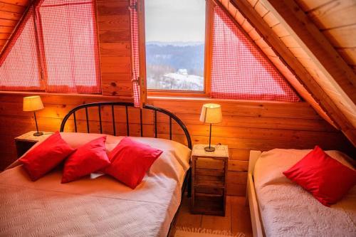 two beds in a room with two windows at Kućica na brijegu in Selnica