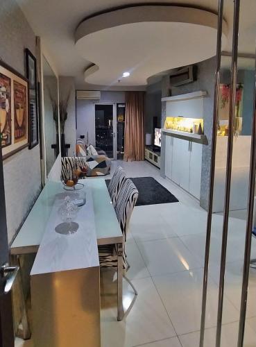 a kitchen and living room with a table and chairs at Cosmo mansion apartment in Jakarta