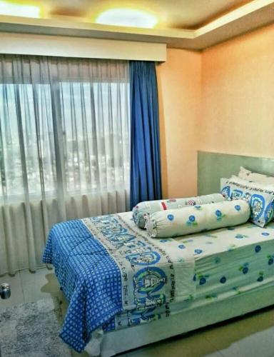 1 Schlafzimmer mit 2 Betten und einem Fenster in der Unterkunft Cosmo mansion apartment in Jakarta