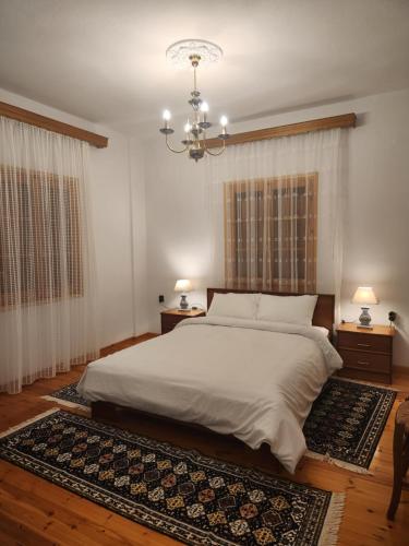 a bedroom with a large bed and a chandelier at Georgia House Portaria in Portaria