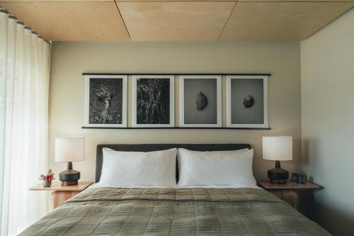 a bedroom with a bed with three pictures on the wall at PACIFIC 19 Kona in Kailua-Kona