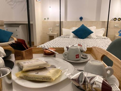 uma mesa com um conjunto de chá sobre ele com uma cama em D'Angiò Rooms-Manfredi Homes&Villas em Manfredonia