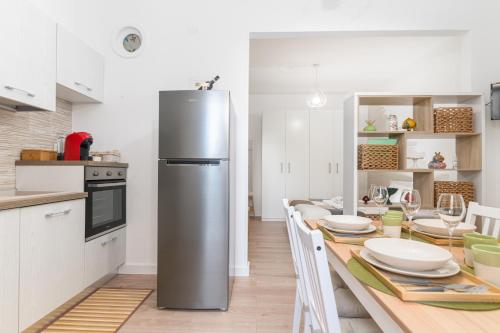 een keuken met een koelkast en een tafel met borden bij Casa Sasà in Ostuni