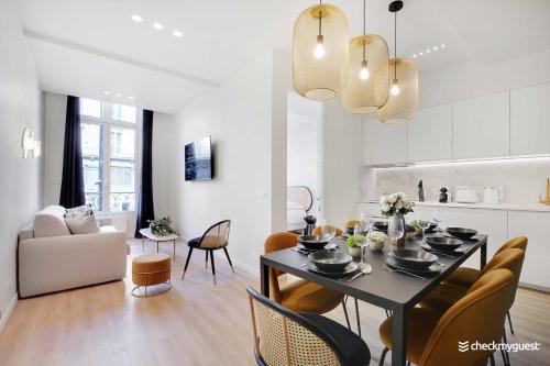 comedor y sala de estar con mesa y sillas en Charming appart 8P - Etienne Marcel Marais, en París