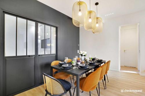une salle à manger avec une table et des chaises noires dans l'établissement Charming apartment - 3BR-8P - Le Marais, à Paris