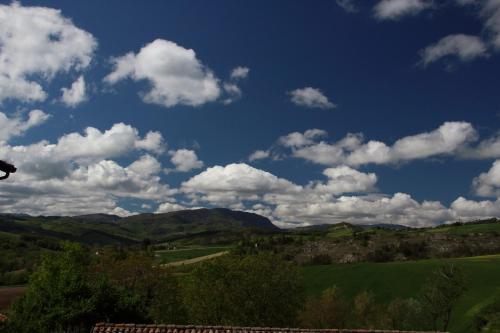 a blue sky with clouds over a green field at La Ca' Tòrta - Rustico ristrutturato in Neviano degli Arduini